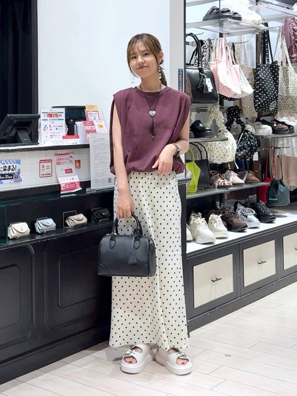 ホワイト系のスカート、ホワイト系のサンダル、ブラック系のショルダーバッグを着用したレディースの夏コーディネートの4枚目の写真