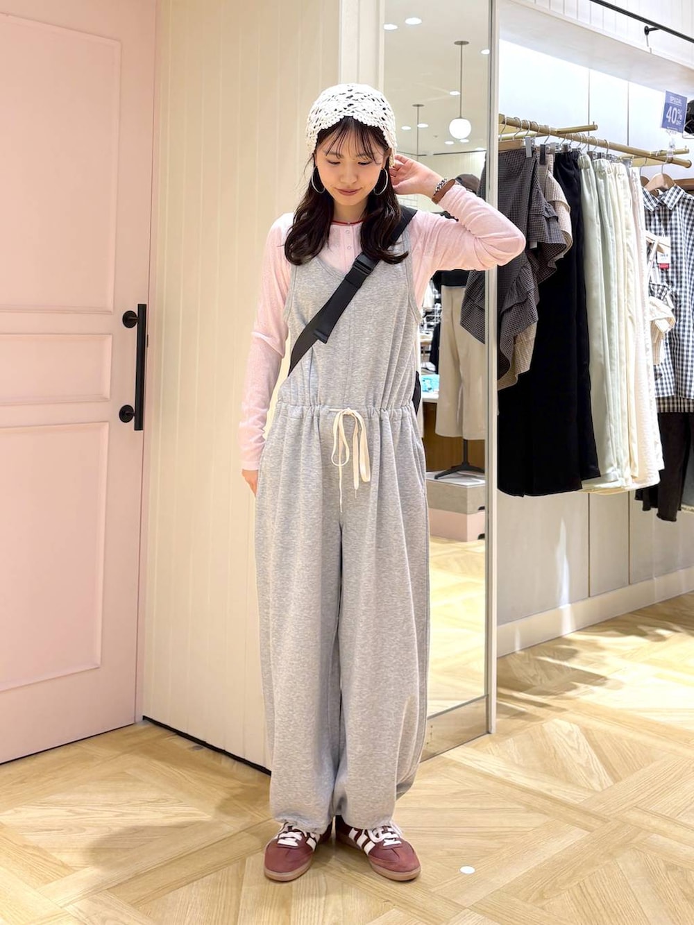 ブラック系のショルダーバッグ、ピンク系のTシャツ/カットソー、グレー系のサロペット/オーバーオールを着用したレディースの春コーディネートの4枚目の写真