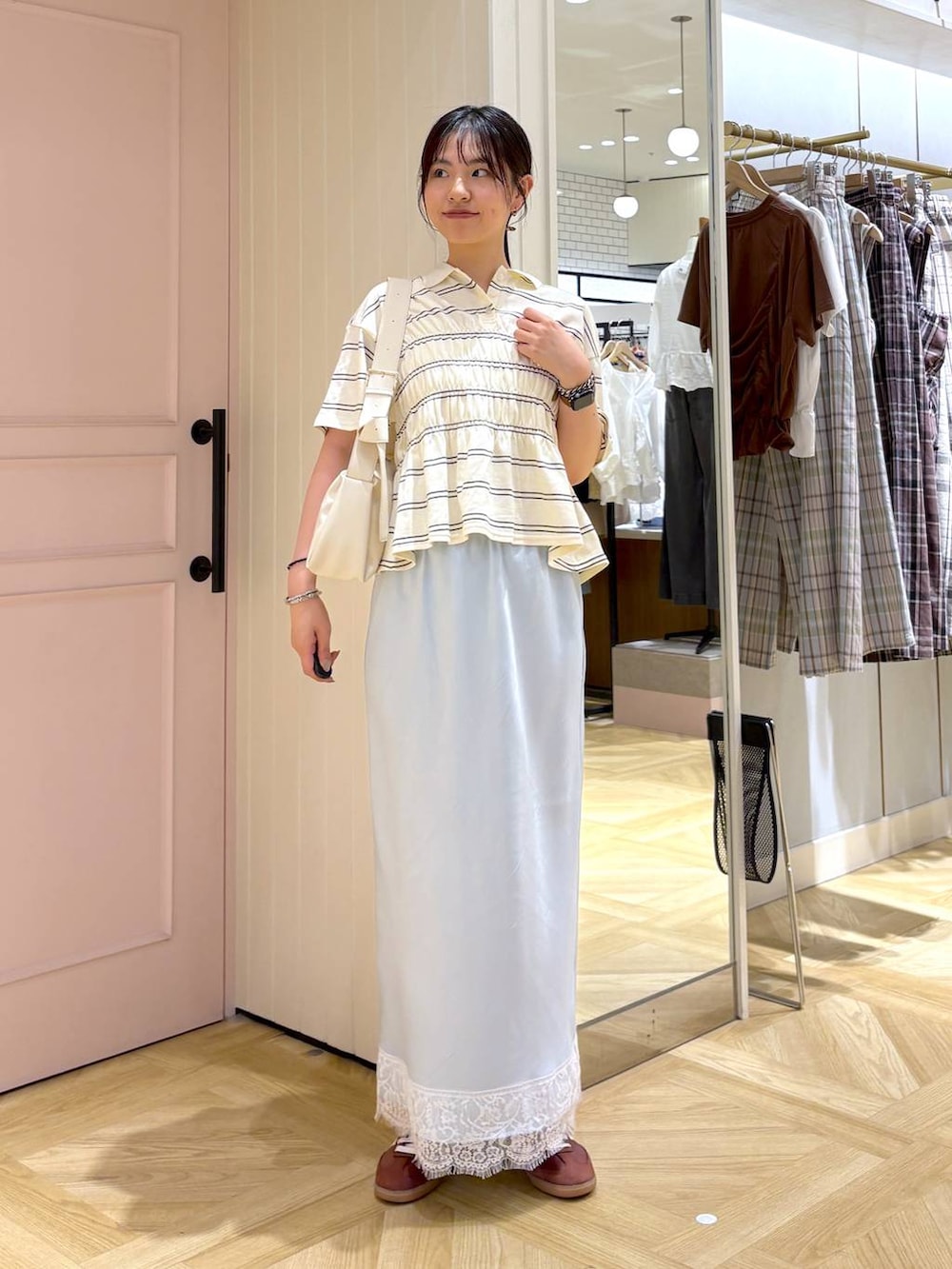 ホワイト系のショルダーバッグ、ブルー系のスカート、ホワイト系のTシャツ/カットソーを着用したレディースの春コーディネートの5枚目の写真