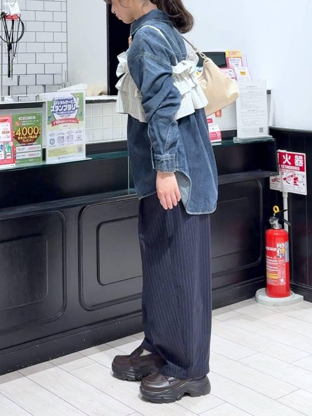 ブルー系のその他パンツ、ブルー系のシャツ/ブラウス、ベージュ系のショルダーバッグを着用したレディースの冬コーディネートの2枚目の写真