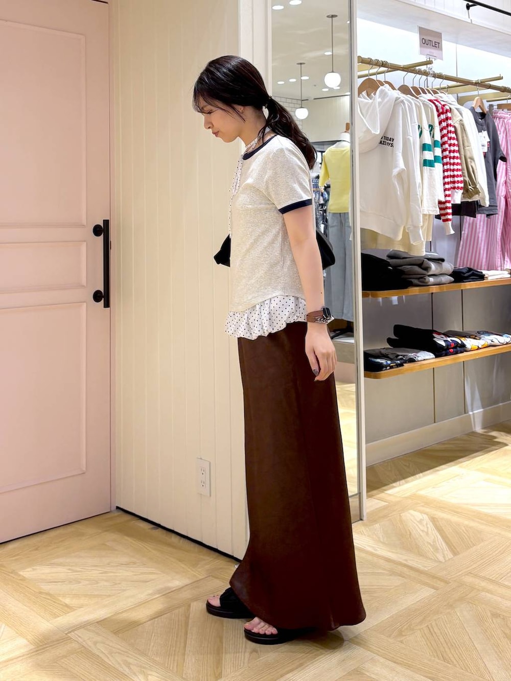 ブラウン系のスカート、ブラック系のサンダル、グレー系のTシャツ/カットソーを着用したレディースの春コーディネートの3枚目の写真