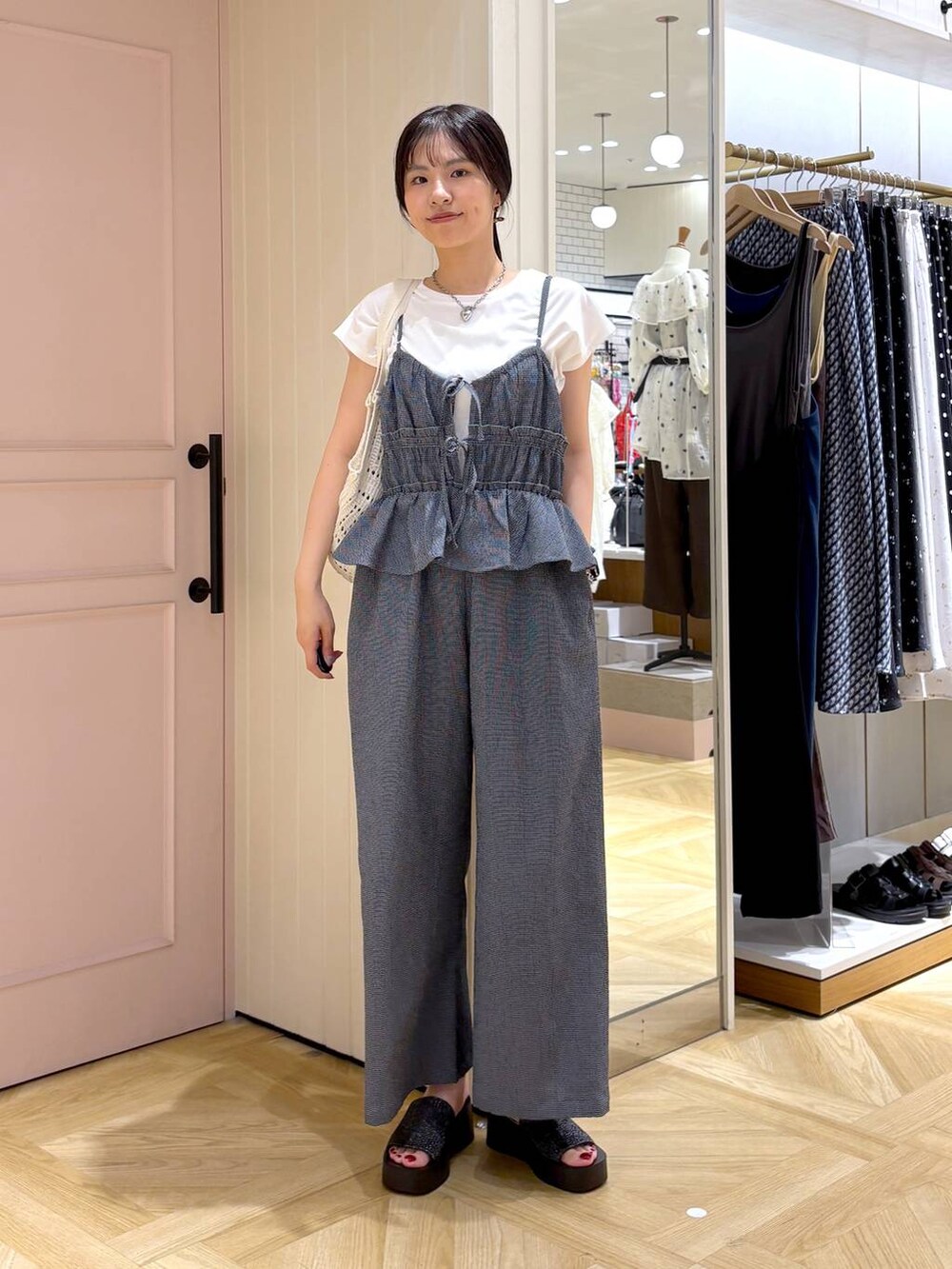 ホワイト系のTシャツ/カットソー、ブラック系のサンダル、ブルー系のサロペット/オーバーオールを着用したレディースの夏コーディネートの4枚目の写真