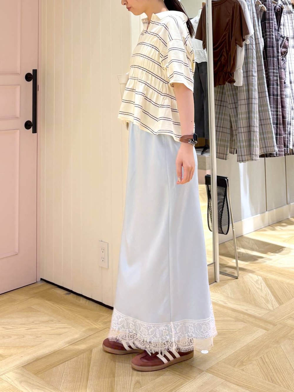 ホワイト系のショルダーバッグ、ブルー系のスカート、ホワイト系のTシャツ/カットソーを着用したレディースの春コーディネートの3枚目の写真