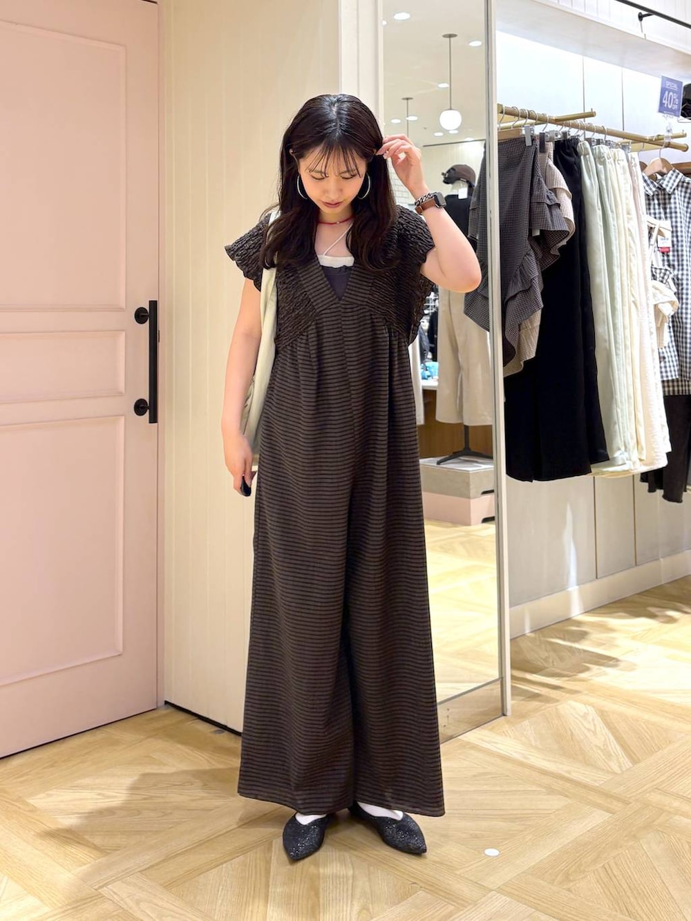 ブラウン系のサロペット/オーバーオール、ブラック系のパンプス、グレー系のタンクトップを着用したレディースの春コーディネートの4枚目の写真