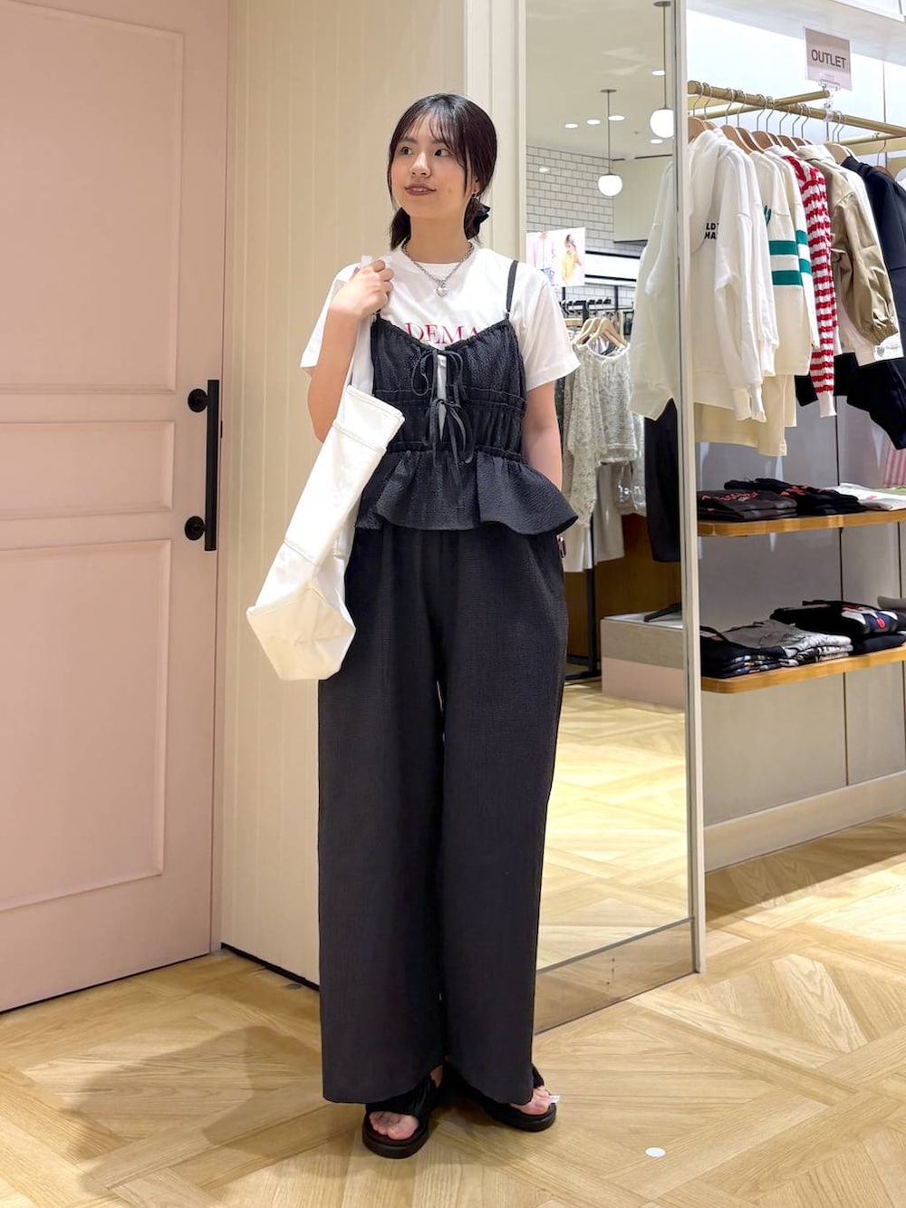 ブラック系のサンダル、ホワイト系のTシャツ/カットソー、ホワイト系のトートバッグを着用したレディースの春コーディネートの3枚目の写真