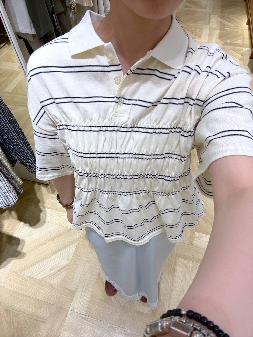 ホワイト系のショルダーバッグ、ブルー系のスカート、ホワイト系のTシャツ/カットソーを着用したレディースの春コーディネートの2枚目の写真