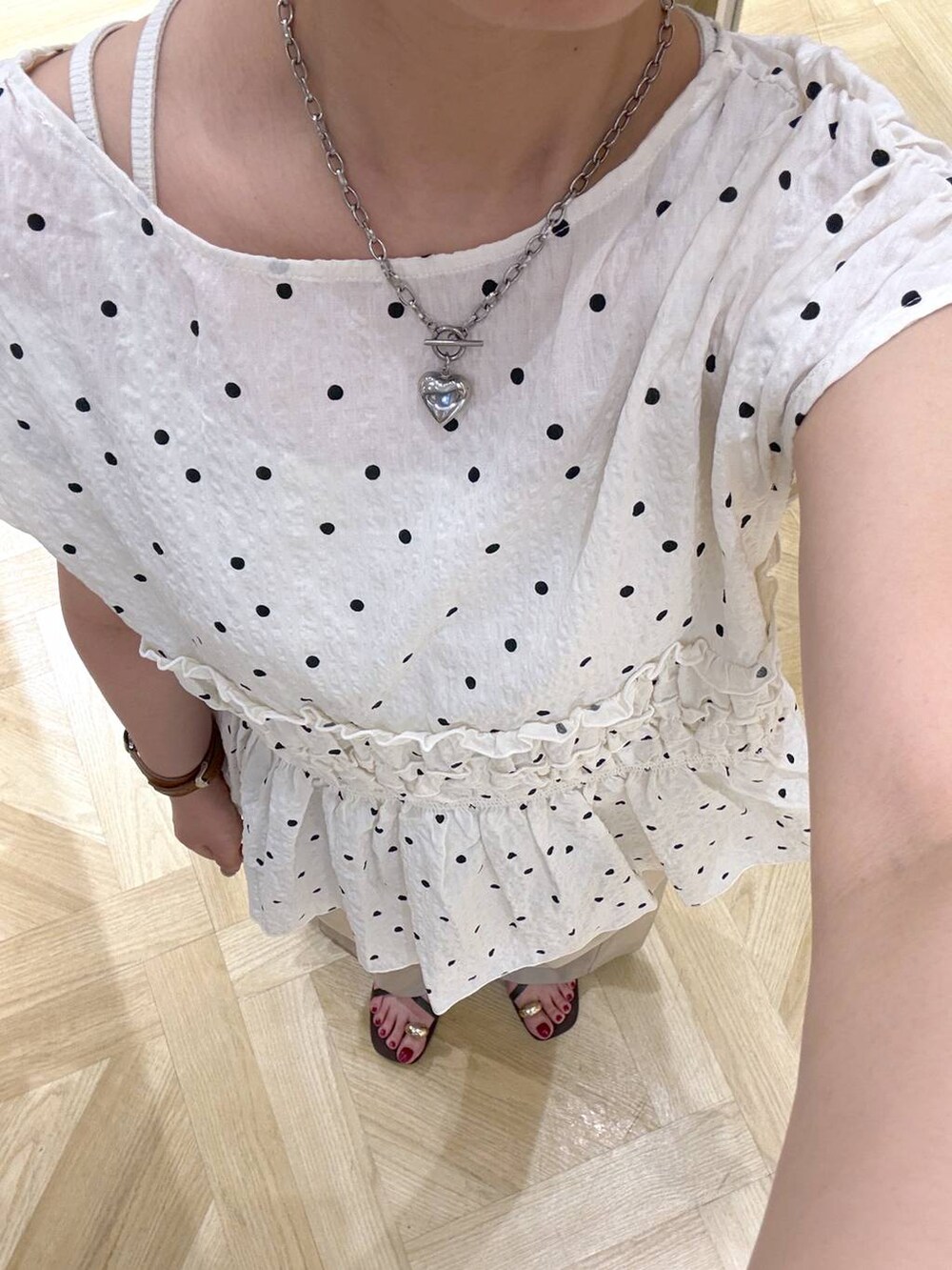 ベージュ系のデニムパンツ、ブラウン系のサンダル、レッド系のトートバッグを着用したレディースの夏コーディネートの2枚目の写真