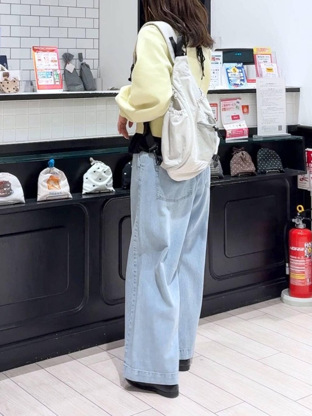 ブルー系のデニムパンツ、グレー系のショルダーバッグ、ブラック系のローファーを着用したレディースの春コーディネートの2枚目の写真