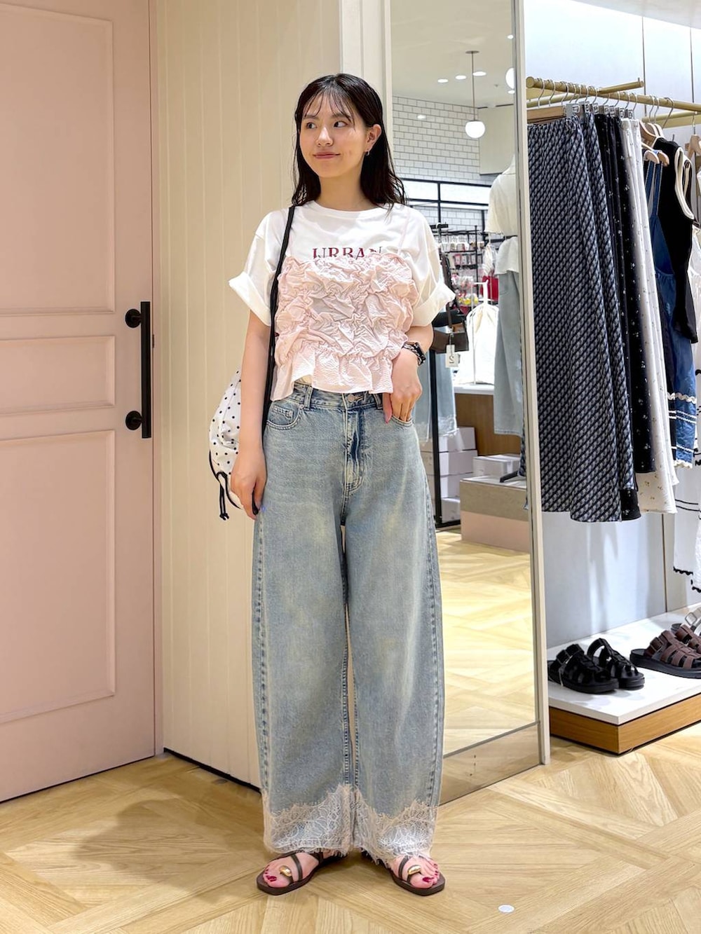 ピンク系のベスト、ブルー系のデニムパンツ、ブラウン系のサンダルを着用したレディースの夏コーディネートの5枚目の写真