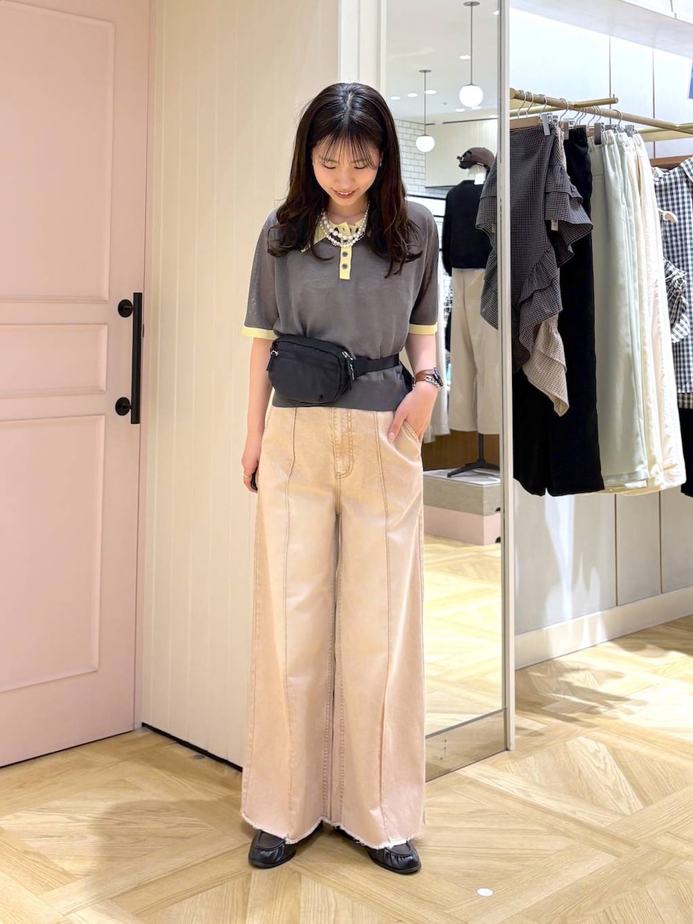 オレンジ系のデニムパンツ、ブラック系のボディバッグ/ウエストポーチ、ブラック系のローファーを着用したレディースの春コーディネートの4枚目の写真