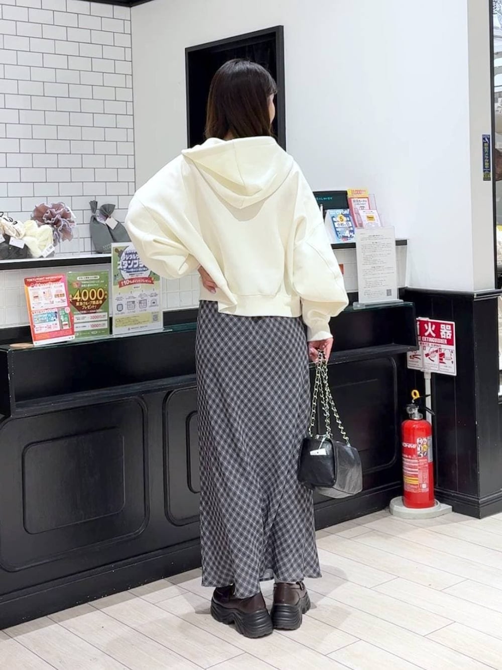 ピンク系のニット/セーター、ベージュ系のパーカー、ブラック系のショルダーバッグを着用したレディースの冬コーディネートの3枚目の写真