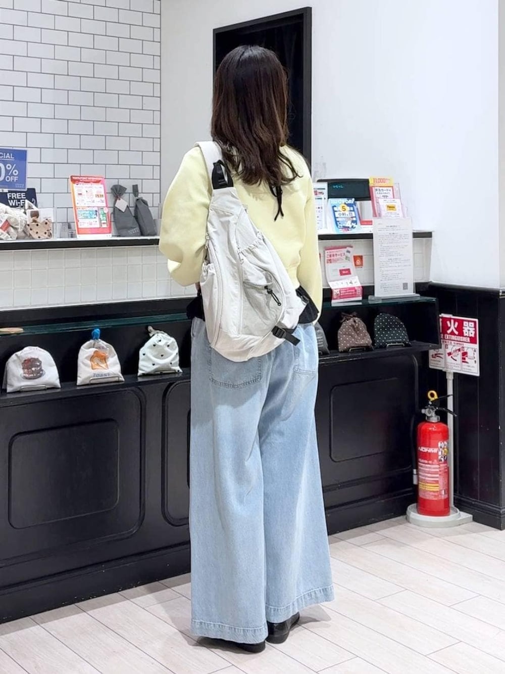 ブルー系のデニムパンツ、グレー系のショルダーバッグ、ブラック系のローファーを着用したレディースの春コーディネートの3枚目の写真