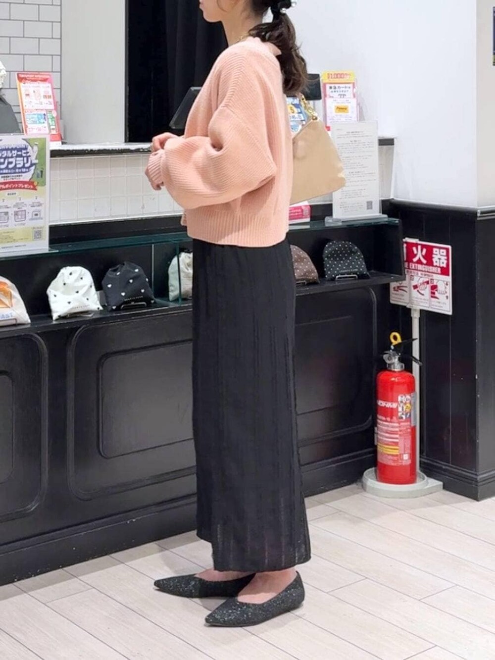 ピンク系のカーディガン/ボレロ、ベージュ系のショルダーバッグ、ブラック系のパンプスを着用したレディースの冬コーディネートの2枚目の写真