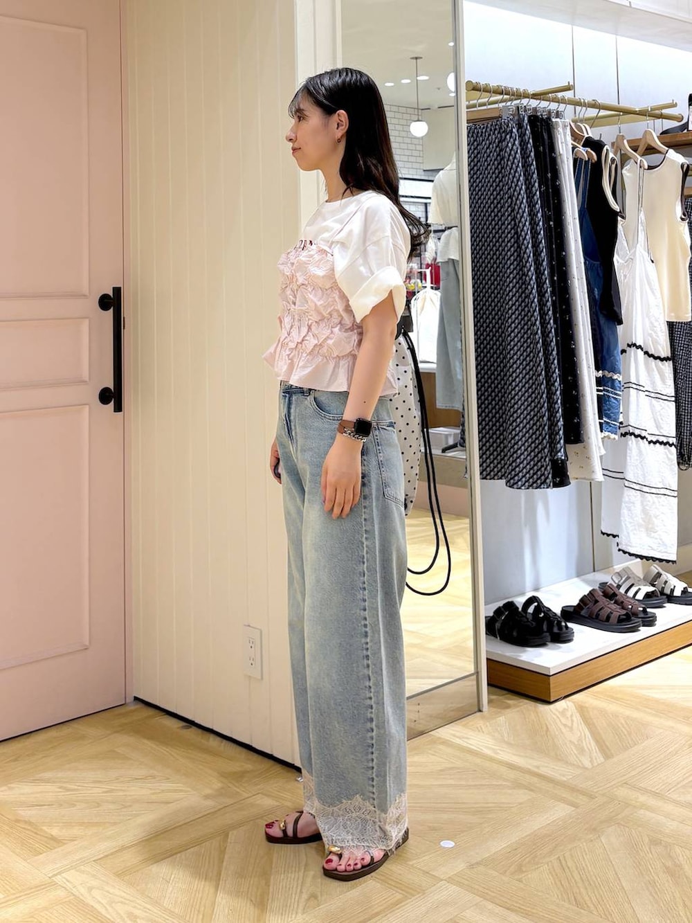 ピンク系のベスト、ブルー系のデニムパンツ、ブラウン系のサンダルを着用したレディースの夏コーディネートの3枚目の写真