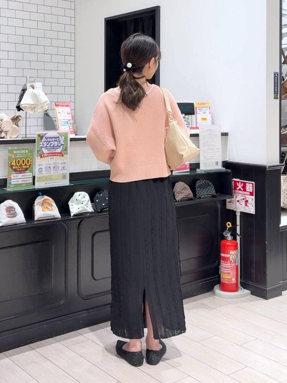 ピンク系のカーディガン/ボレロ、ベージュ系のショルダーバッグ、ブラック系のパンプスを着用したレディースの冬コーディネートの3枚目の写真