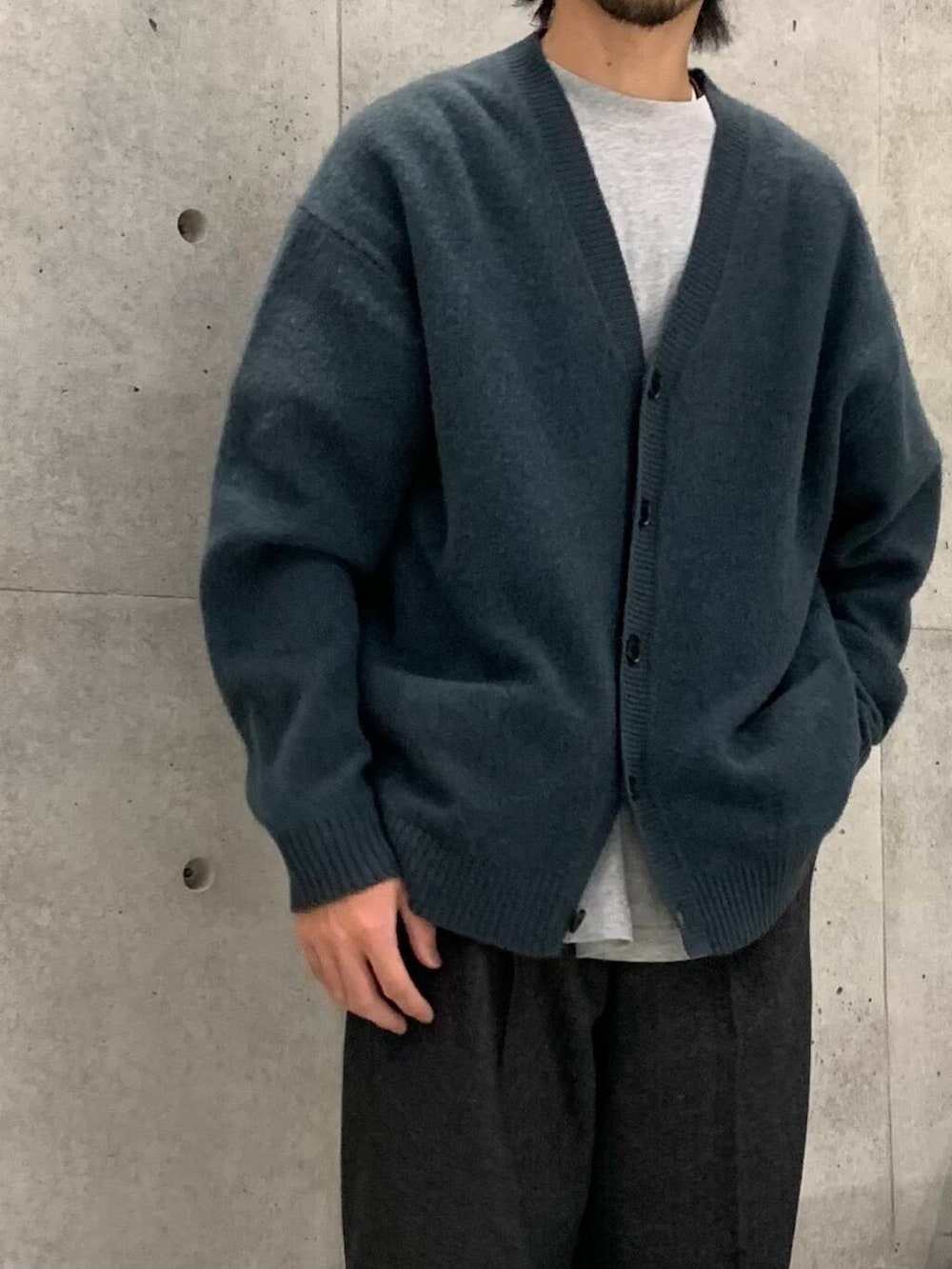 ブラック系のドレスシューズ、ブラック系のチェスターコート、グリーン系のカーディガン/ボレロを着用したメンズの冬コーディネートの5枚目の写真