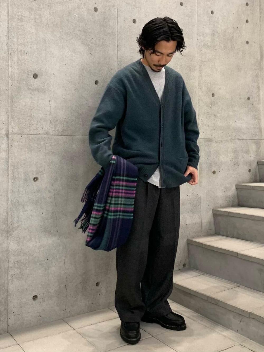 ブラック系のドレスシューズ、ブラック系のチェスターコート、グリーン系のカーディガン/ボレロを着用したメンズの冬コーディネートの3枚目の写真