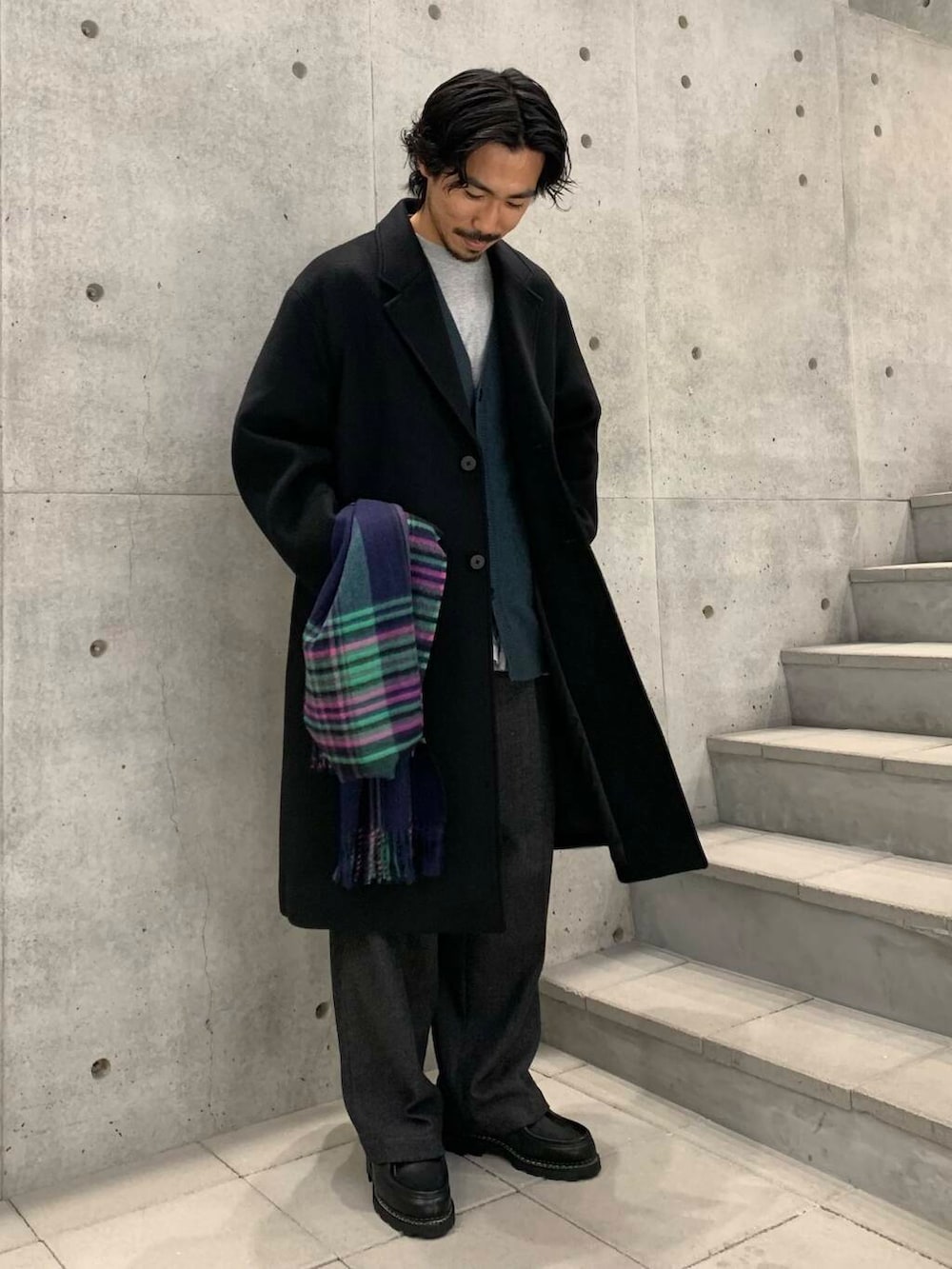 ブラック系のドレスシューズ、ブラック系のチェスターコート、グリーン系のカーディガン/ボレロを着用したメンズの冬コーディネートの2枚目の写真