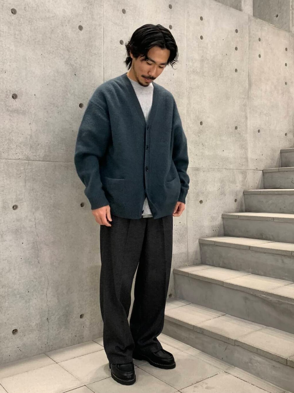 ブラック系のドレスシューズ、ブラック系のチェスターコート、グリーン系のカーディガン/ボレロを着用したメンズの冬コーディネートの4枚目の写真