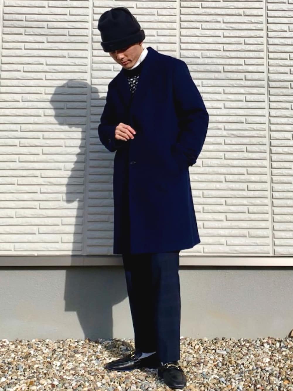 ブルー系のチェスターコート、ブルー系のその他パンツ、ブラック系のローファーを着用したメンズの冬コーディネートの2枚目の写真