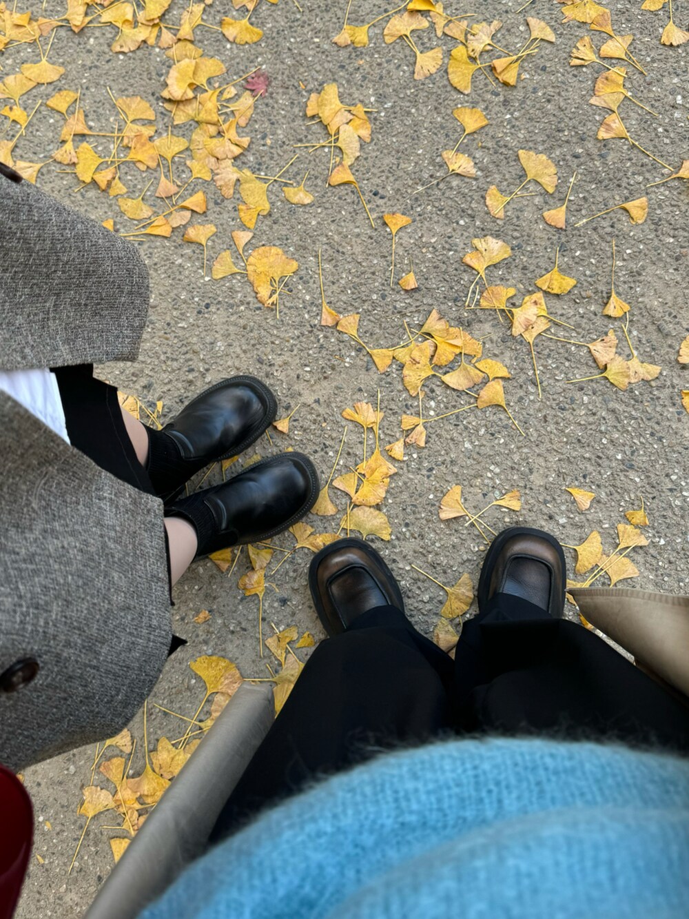 ブルー系のニット/セーター、ベージュ系のトレンチコート、ブラック系のスラックスを着用したメンズの冬コーディネートの3枚目の写真