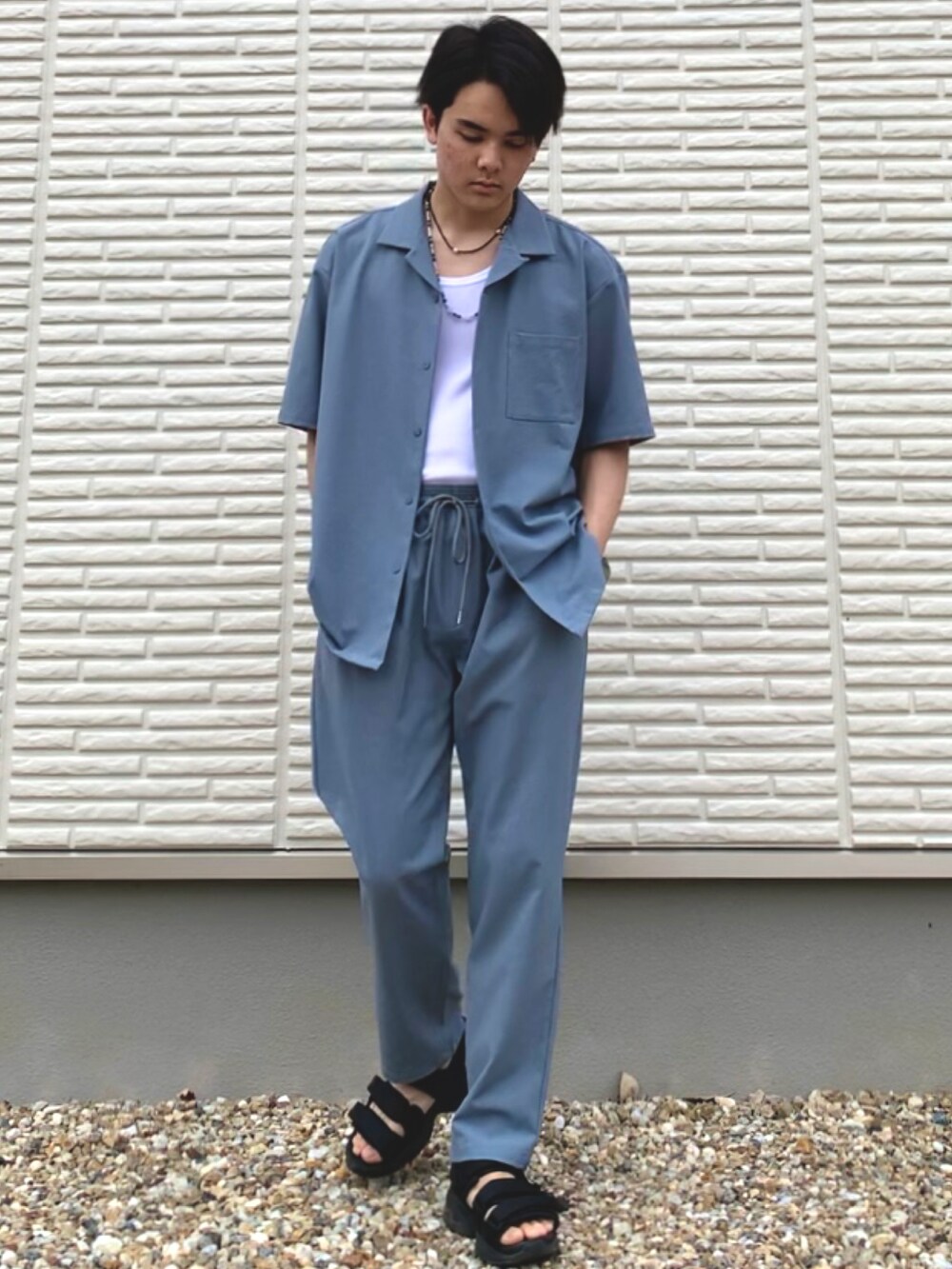 ブルー系のセットアップ、ブラック系のサンダルを着用したメンズの春コーディネートの2枚目の写真