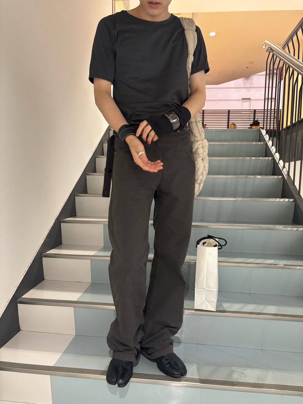 グレー系のTシャツ/カットソー、グレー系のパンツ、ブラック系のブーツを着用したメンズの秋コーディネートの2枚目の写真