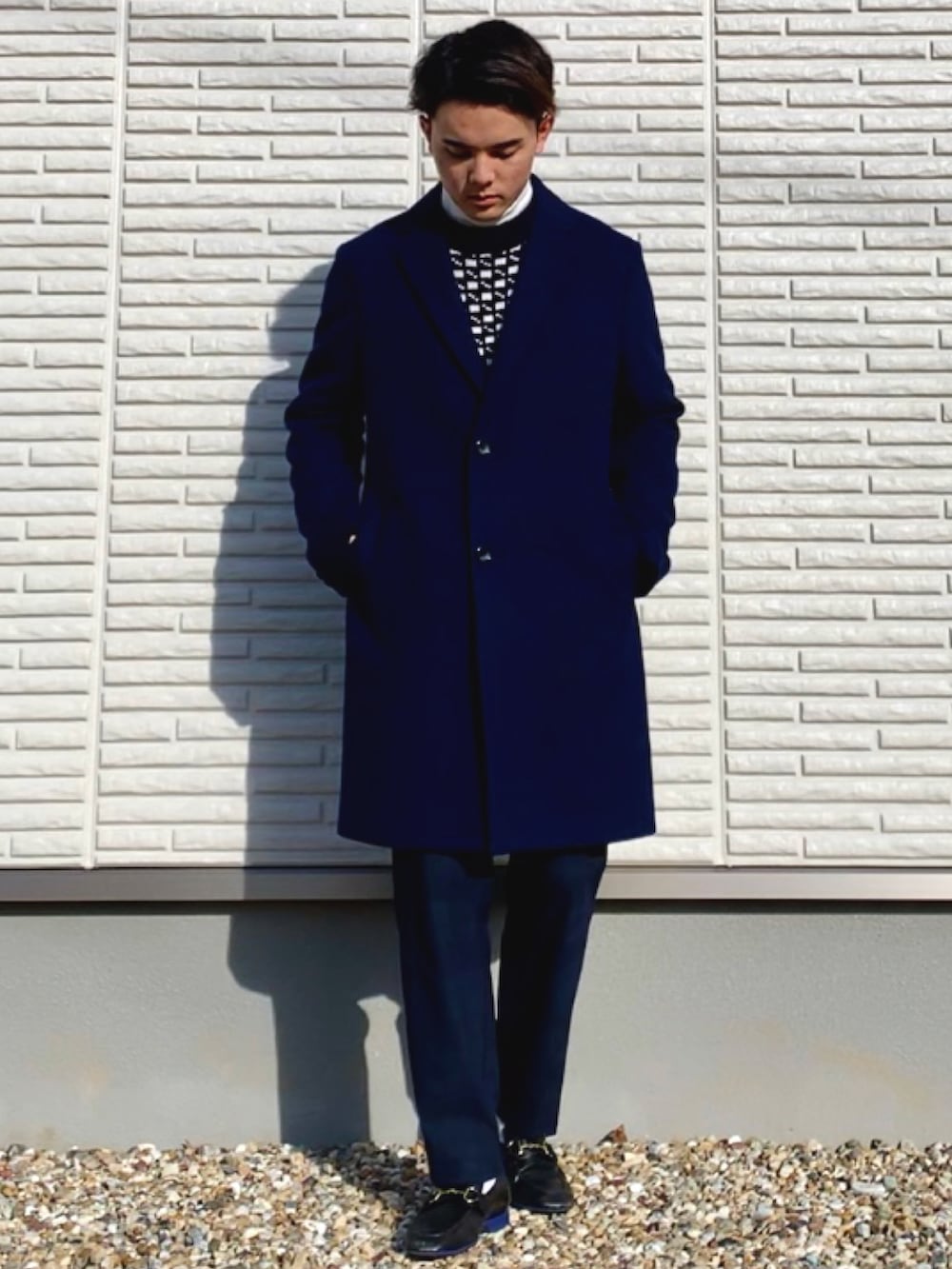 ブルー系のチェスターコート、ブルー系のその他パンツ、ブラック系のローファーを着用したメンズの冬コーディネートの3枚目の写真