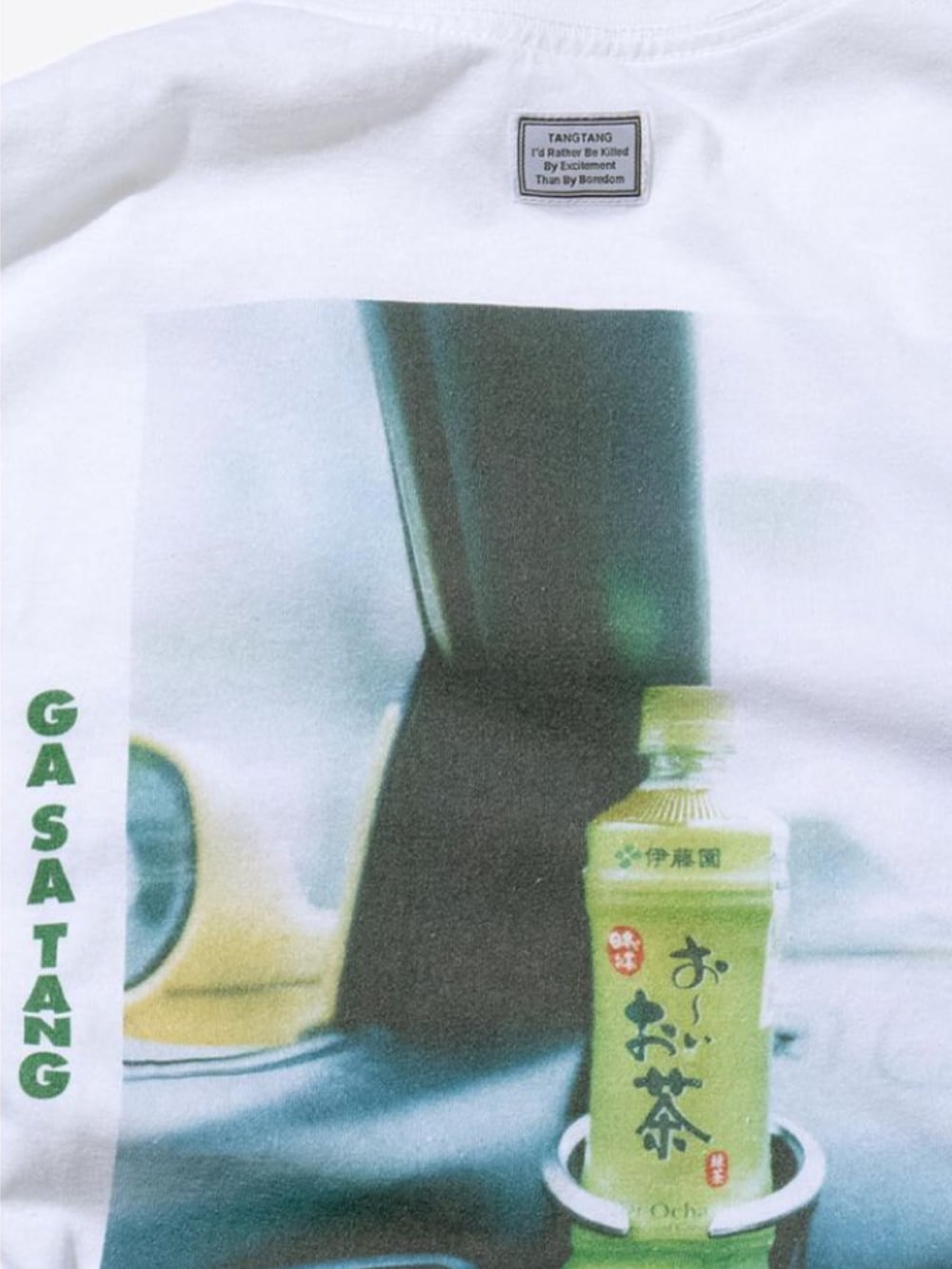 ホワイト系のTシャツ/カットソー、ホワイト系のトレンチコート、グリーン系のバッグを着用したメンズの秋コーディネートの2枚目の写真