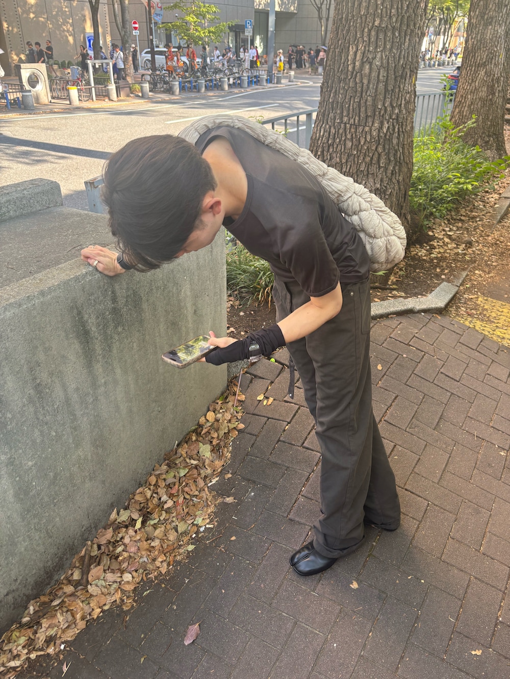 グレー系のTシャツ/カットソー、グレー系のパンツ、ブラック系のブーツを着用したメンズの秋コーディネートの3枚目の写真