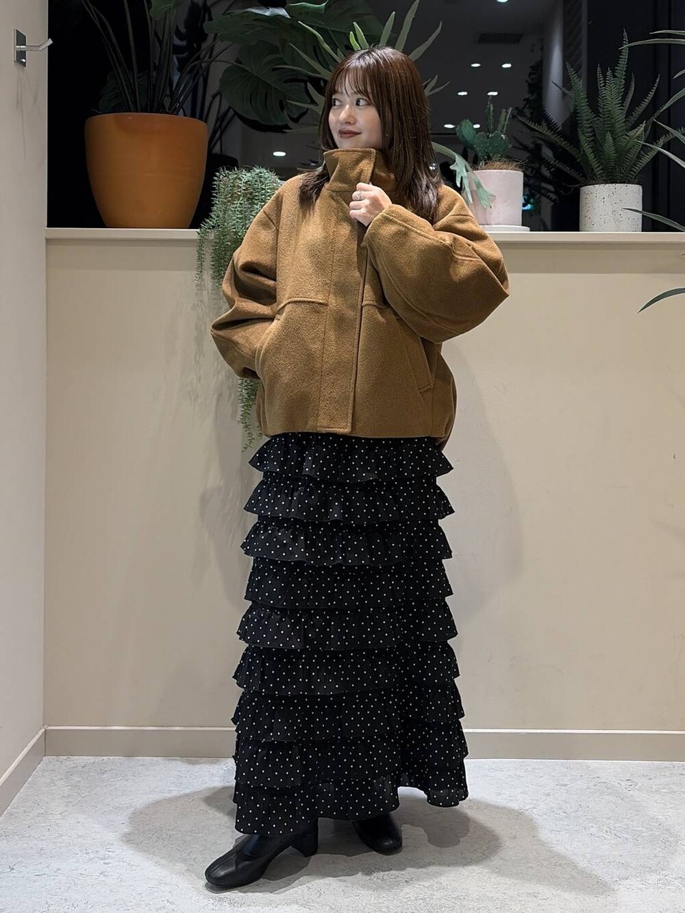 ブラウン系のブルゾン、その他のスカート、ブラック系のブーツを着用したレディースの秋コーディネートの2枚目の写真