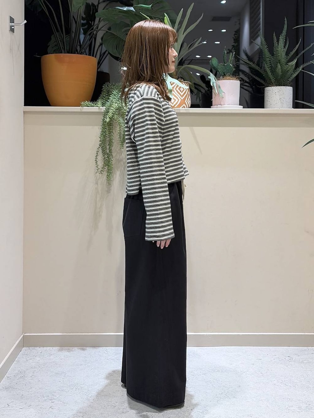 ブラック系のデニムパンツ、ブラウン系のローファー、グレー系のカーディガン/ボレロを着用したレディースの春コーディネートの3枚目の写真