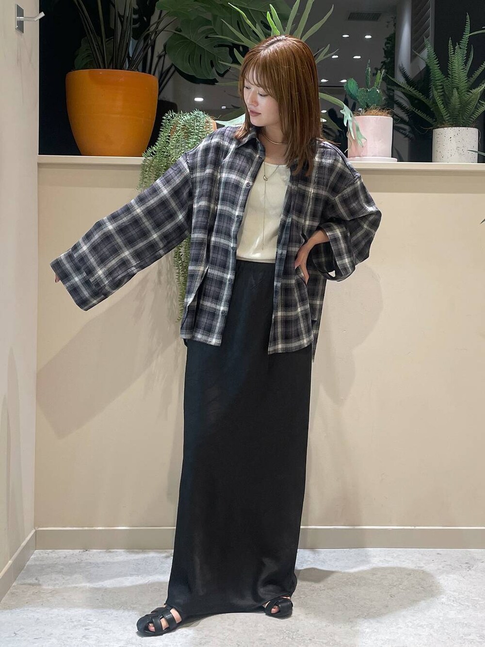 ブラック系のスカート、ブラック系のサンダル、グレー系のシャツ/ブラウスを着用したレディースの夏コーディネートの2枚目の写真