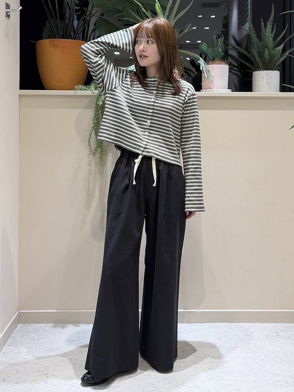 ブラック系のデニムパンツ、ブラウン系のローファー、グレー系のカーディガン/ボレロを着用したレディースの春コーディネートの2枚目の写真