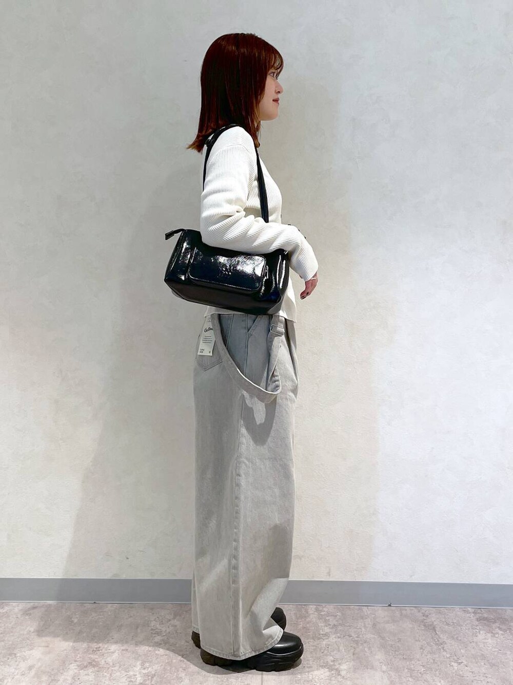 ブラック系のブーツ、ブラック系のショルダーバッグ、ブラック系のTシャツ/カットソーを着用したレディースの冬コーディネートの3枚目の写真