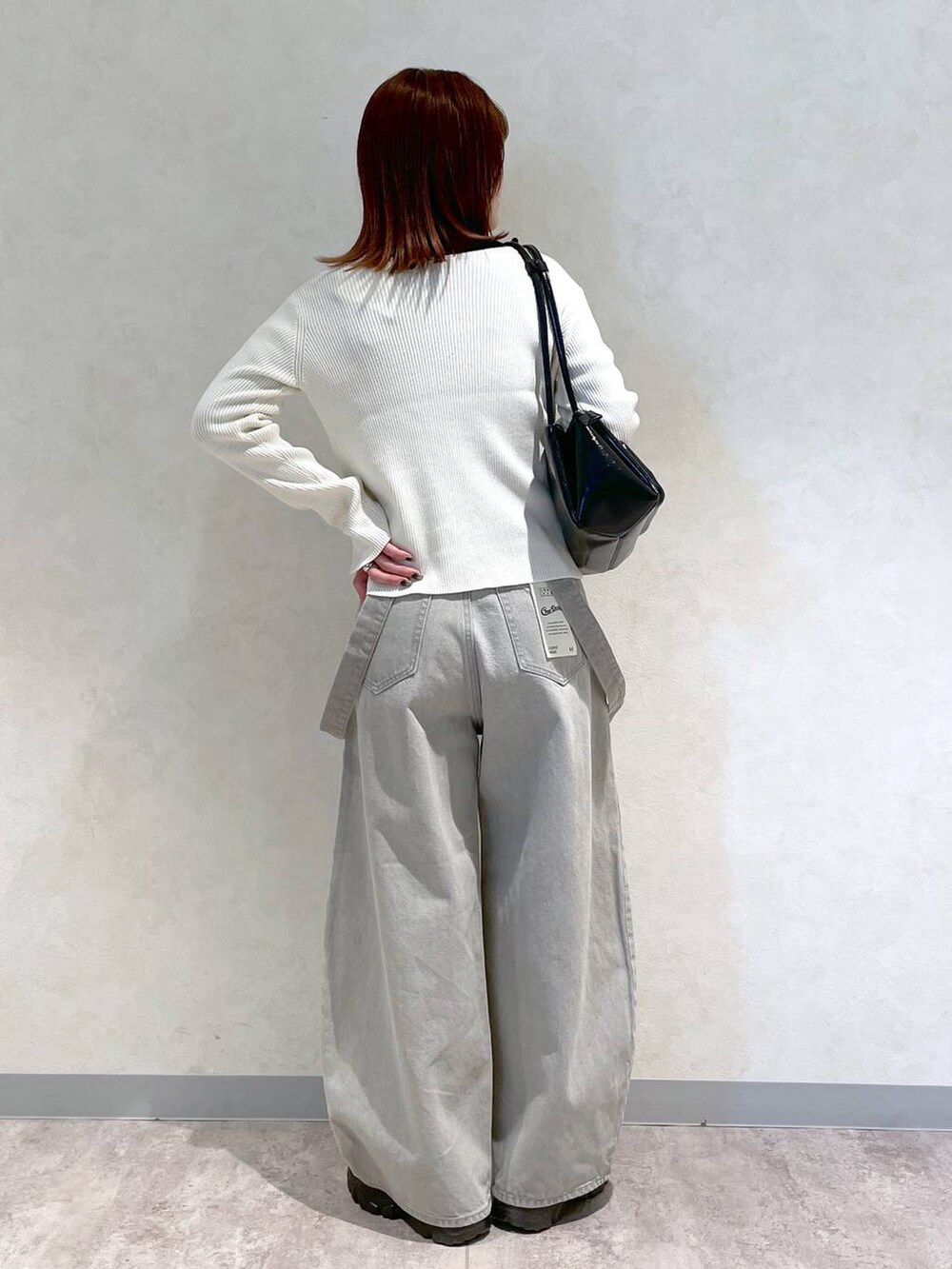 ブラック系のブーツ、ブラック系のショルダーバッグ、ブラック系のTシャツ/カットソーを着用したレディースの冬コーディネートの4枚目の写真