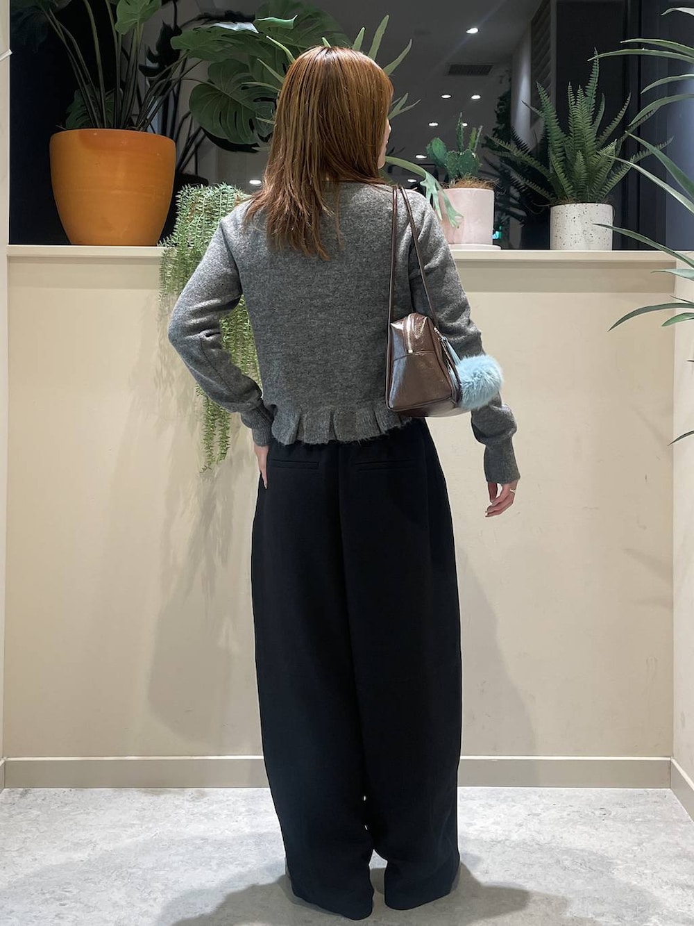 ブラック系のその他パンツ、ブラウン系のボストンバッグ、グレー系のニット/セーターを着用したレディースの秋コーディネートの3枚目の写真