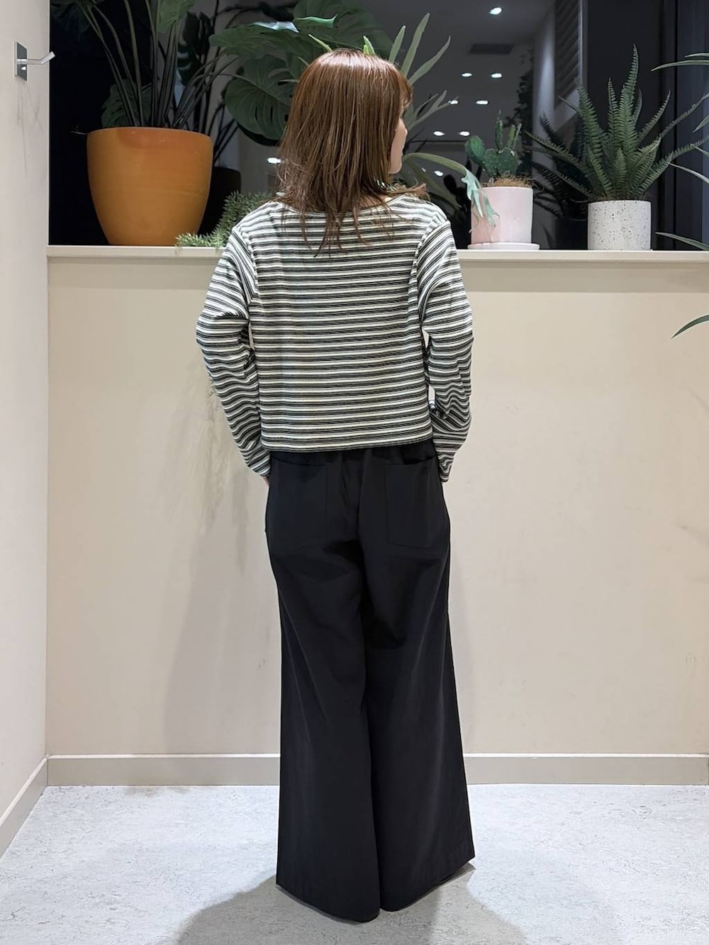 ブラック系のデニムパンツ、ブラウン系のローファー、グレー系のカーディガン/ボレロを着用したレディースの春コーディネートの4枚目の写真