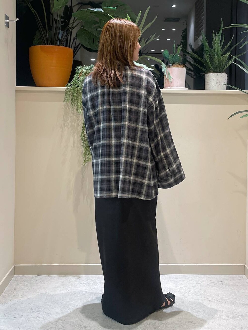 ブラック系のスカート、ブラック系のサンダル、グレー系のシャツ/ブラウスを着用したレディースの夏コーディネートの3枚目の写真