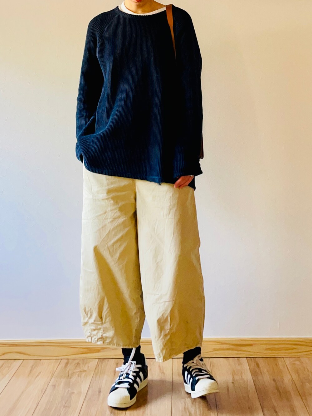 ブルー系のトップス、ブラウン系のショルダーバッグ、ベージュ系のパンツを着用したレディースの春コーディネートの2枚目の写真
