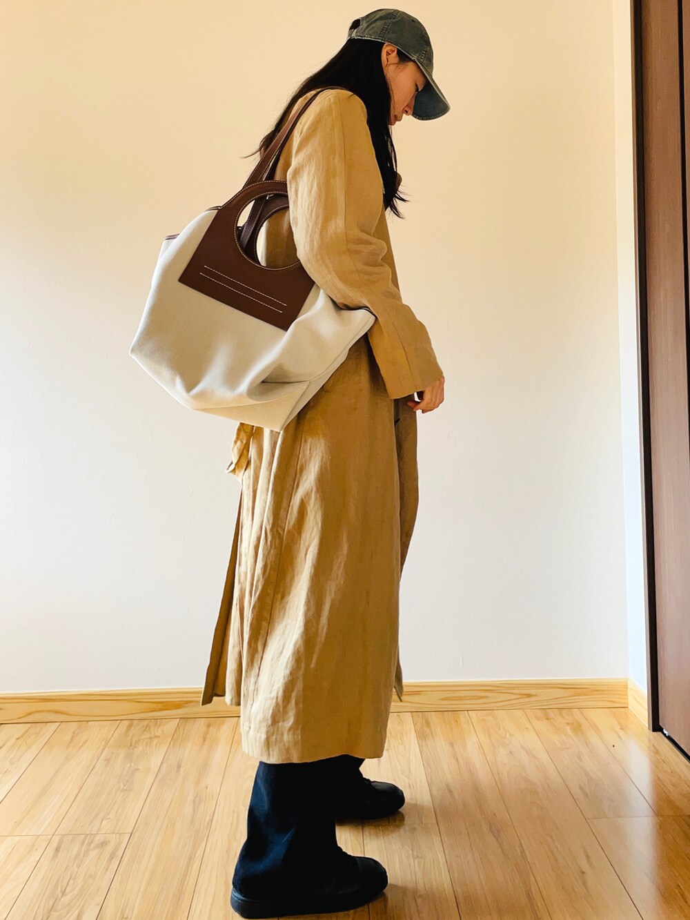 ベージュ系のトレンチコート、ブラック系のデニムパンツ、ブラック系のスニーカーを着用したレディースの春コーディネートの3枚目の写真