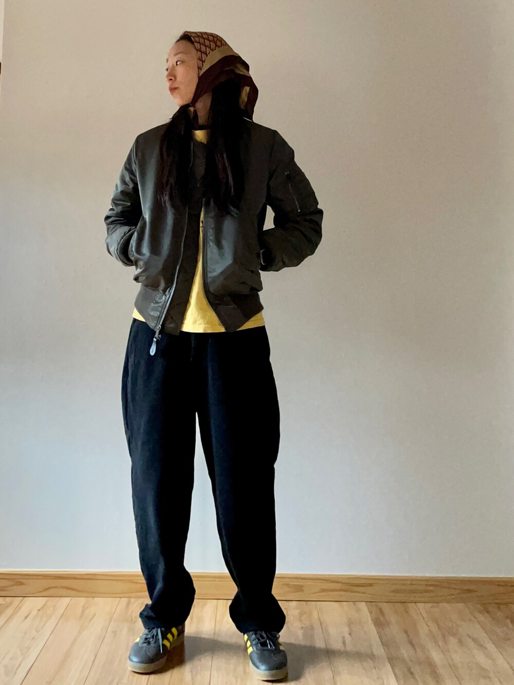 イエロー系のTシャツ/カットソー、ブラック系のスラックス、グリーン系のスニーカーを着用したレディースの秋コーディネートの2枚目の写真