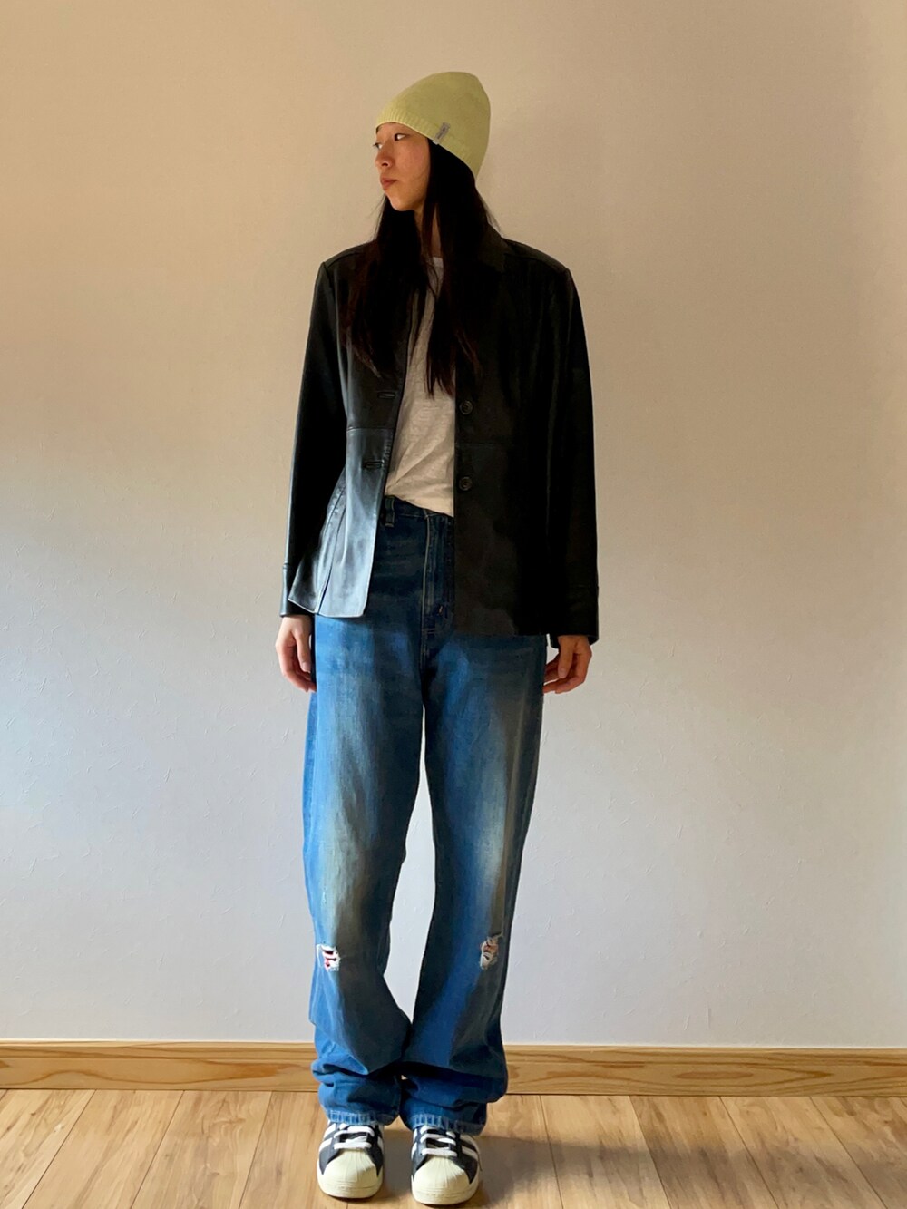 ブラック系のジャケット/アウター、ブルー系のデニムパンツ、ブラック系のスニーカーを着用したレディースの秋コーディネートの2枚目の写真