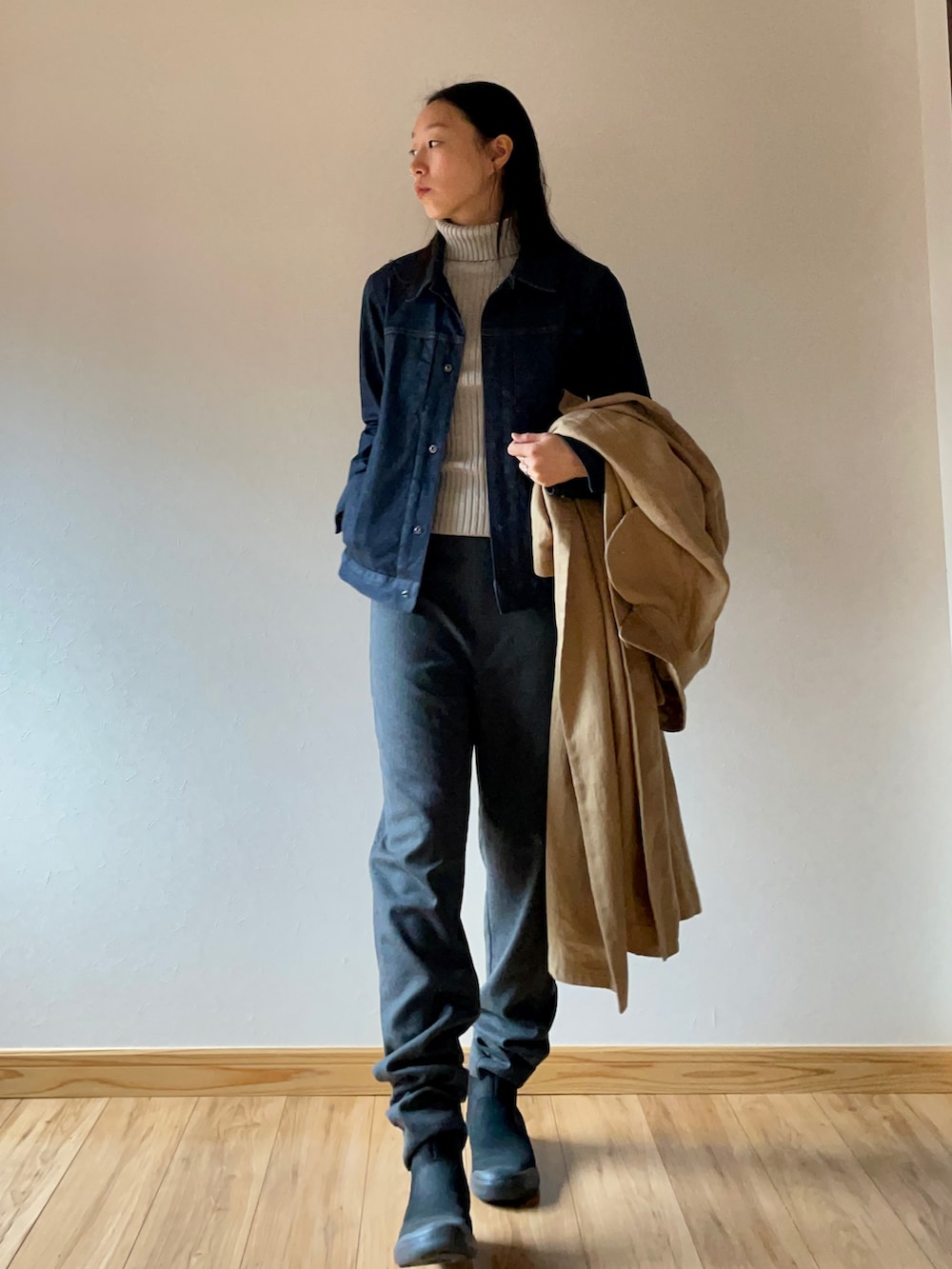 ブラック系のブーツ、ベージュ系のニット/セーター、ベージュ系のトレンチコートを着用したレディースの秋コーディネートの2枚目の写真