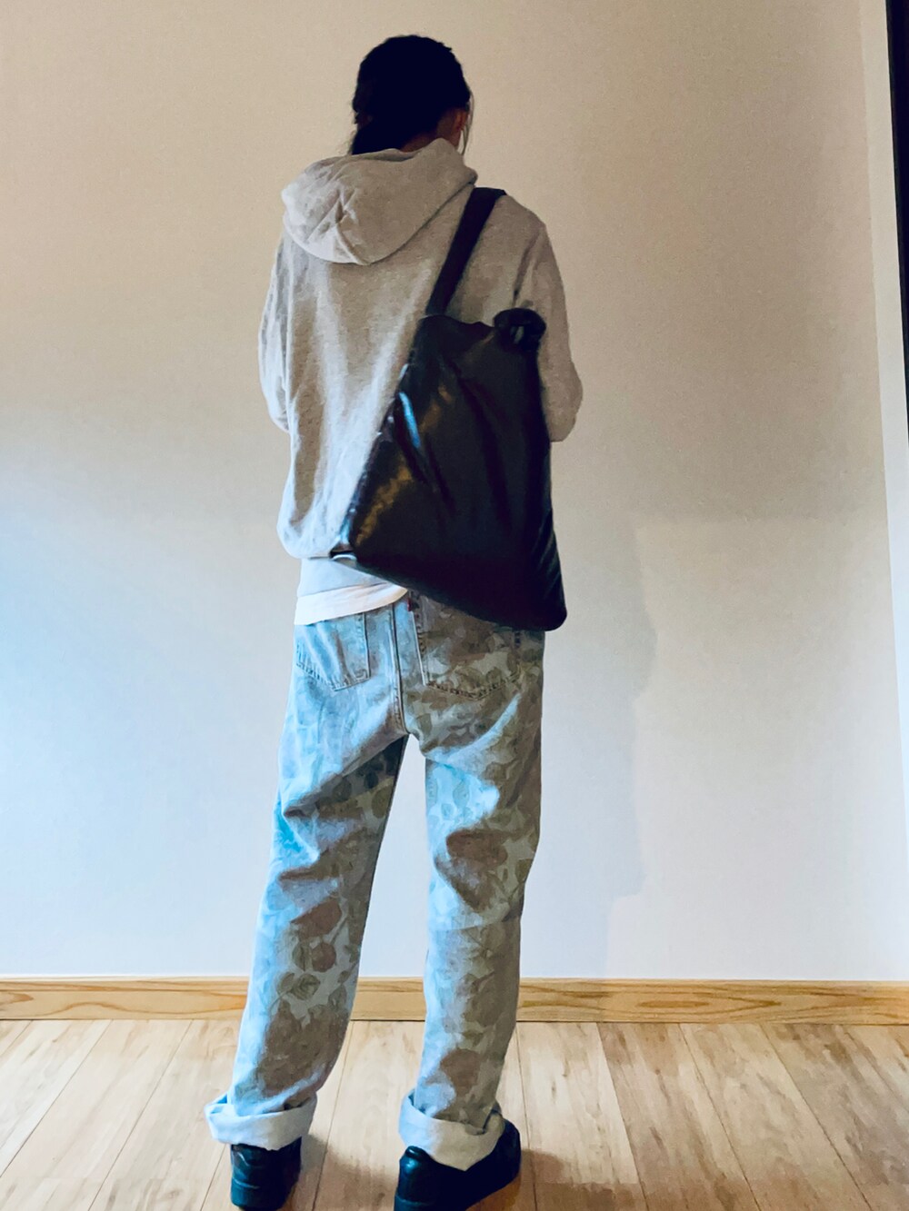 グレー系のパーカー、ブラック系のスニーカー、ブラウン系のショルダーバッグを着用したレディースの秋コーディネートの3枚目の写真