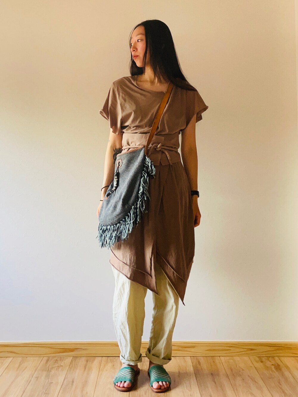 ブラウン系のチュニック、ブルー系のショルダーバッグ、ベージュ系のパンツを着用したレディースの夏コーディネートの2枚目の写真