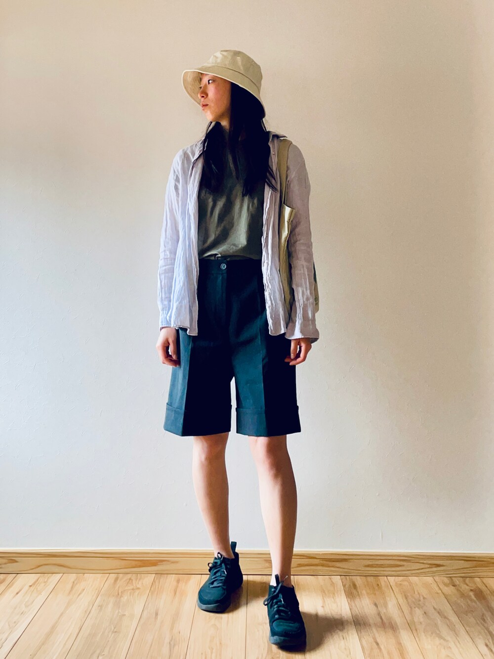 グレー系のシャツ/ブラウス、グレー系のパンツ、ブラック系のスニーカーを着用したレディースの春コーディネートの2枚目の写真