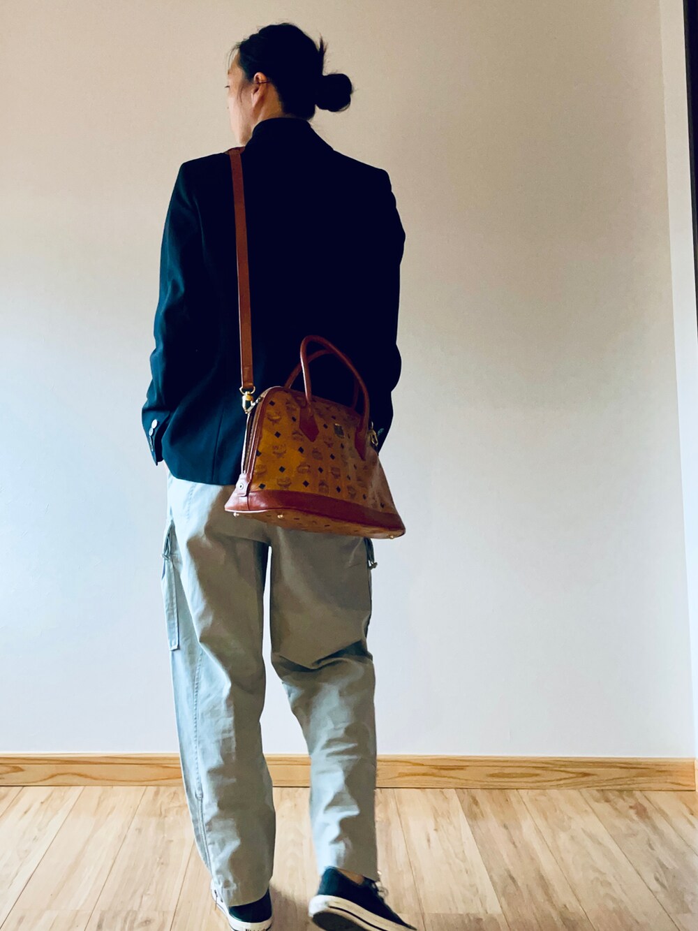 ブラック系のテーラードジャケット、ブラック系のトップス、ブラウン系のショルダーバッグを着用したレディースの秋コーディネートの2枚目の写真