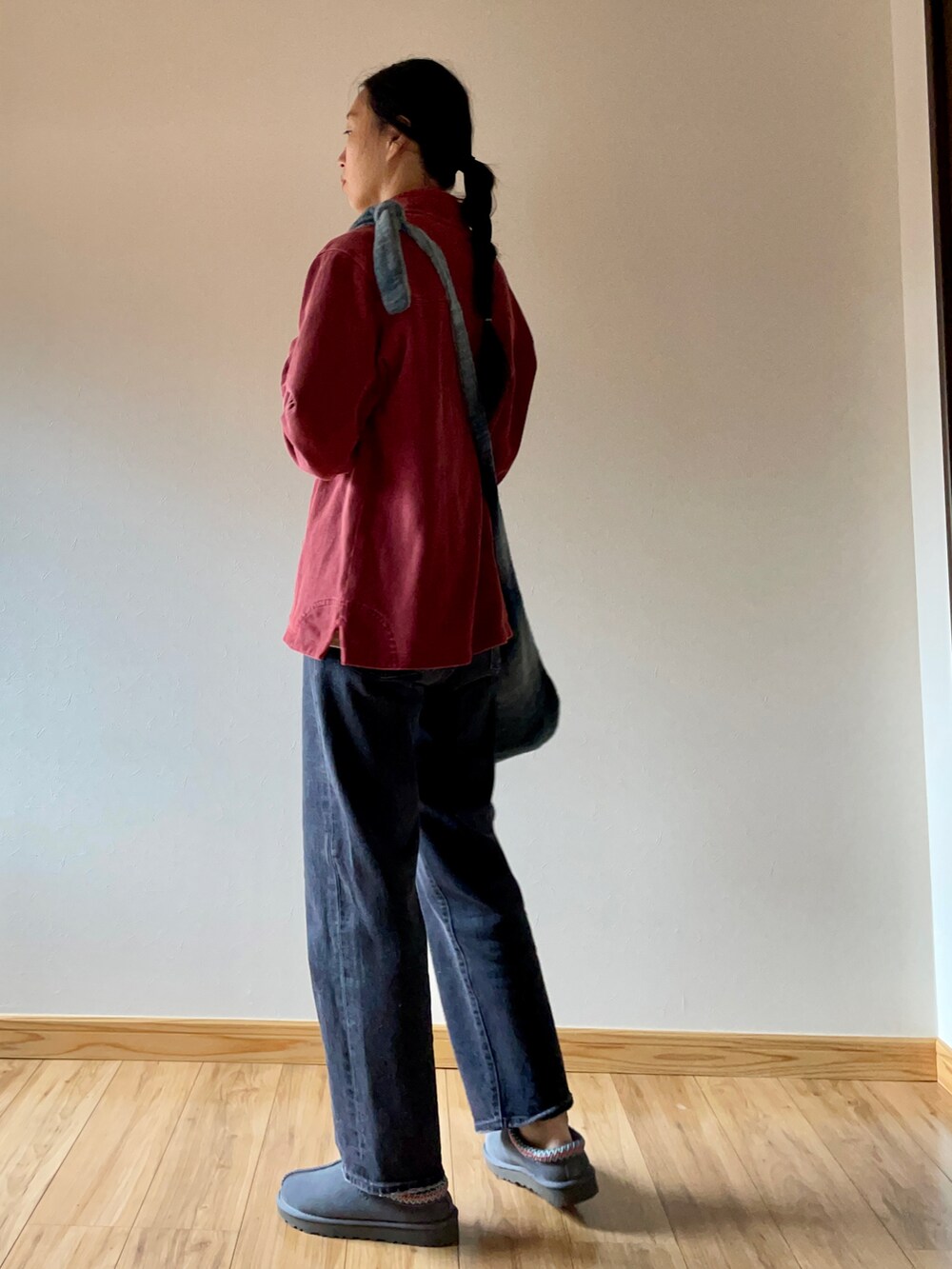 レッド系のスウェット、グレー系のショルダーバッグ、グレー系のデニムパンツを着用したレディースの秋コーディネートの2枚目の写真