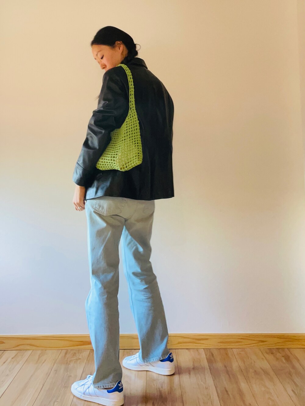 ベージュ系のTシャツ/カットソー、ブルー系のデニムパンツ、ホワイト系のスニーカーを着用したレディースの秋コーディネートの2枚目の写真